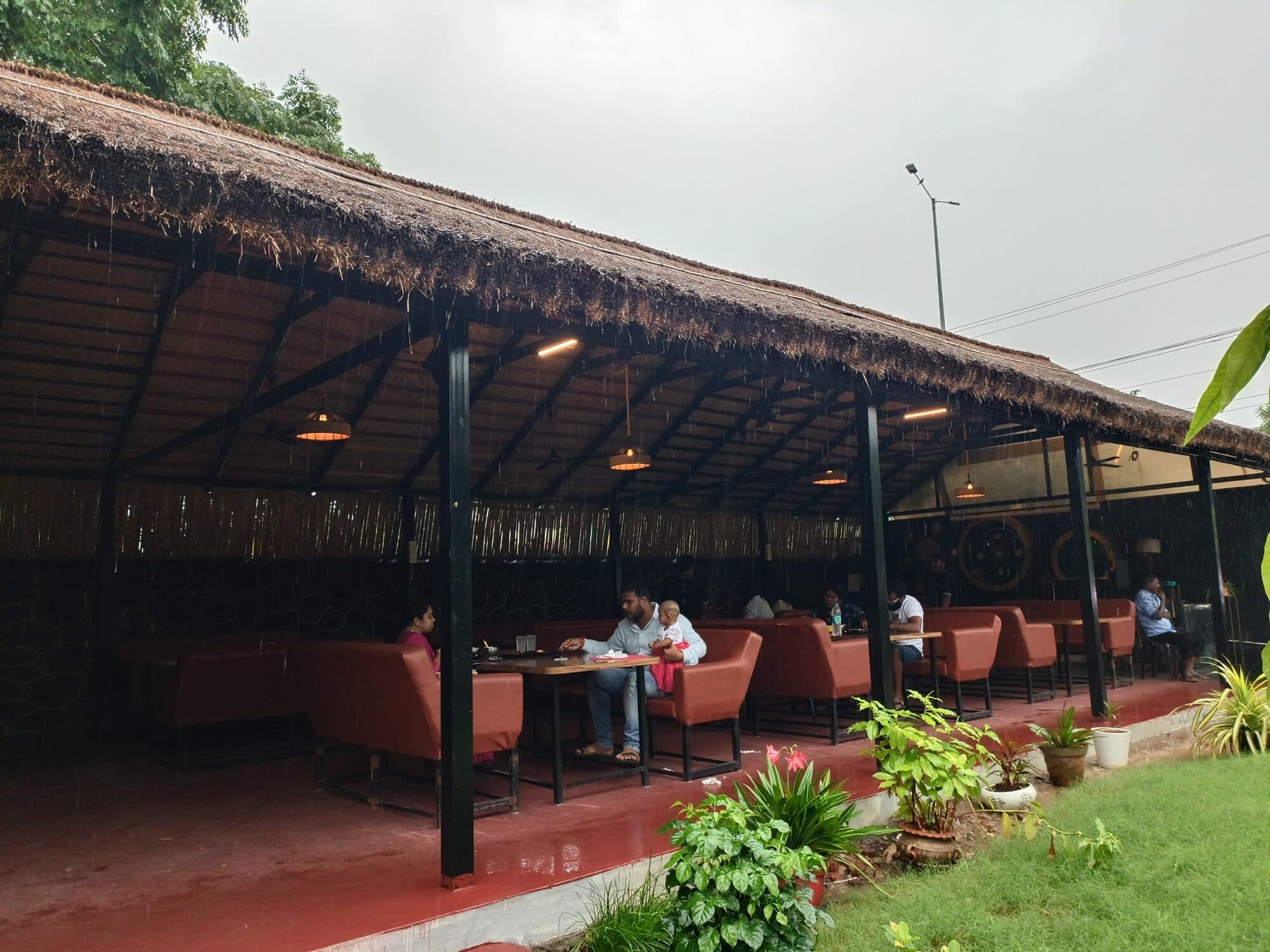 A live waterfall cascading beside outdoor dining tables at Aruvi Restaurant on ECR, Chennai